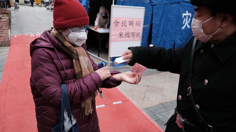 Woman measuring body temperature and wearing a face mask
