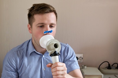 young man testing breathing function by spirometry